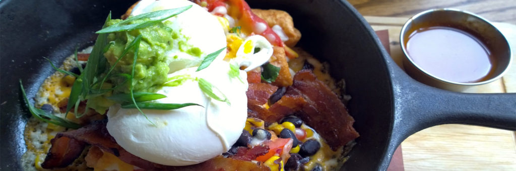 Frühstück mit einer gusseisernen Pfanne - pochierte Eiser, Speck und Bohnen